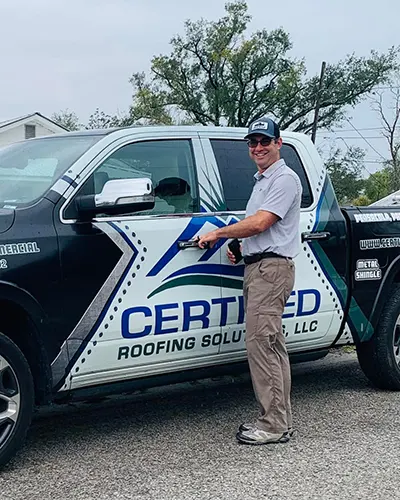 Certified Roofing Specialist Standing in front of wrapped truck.